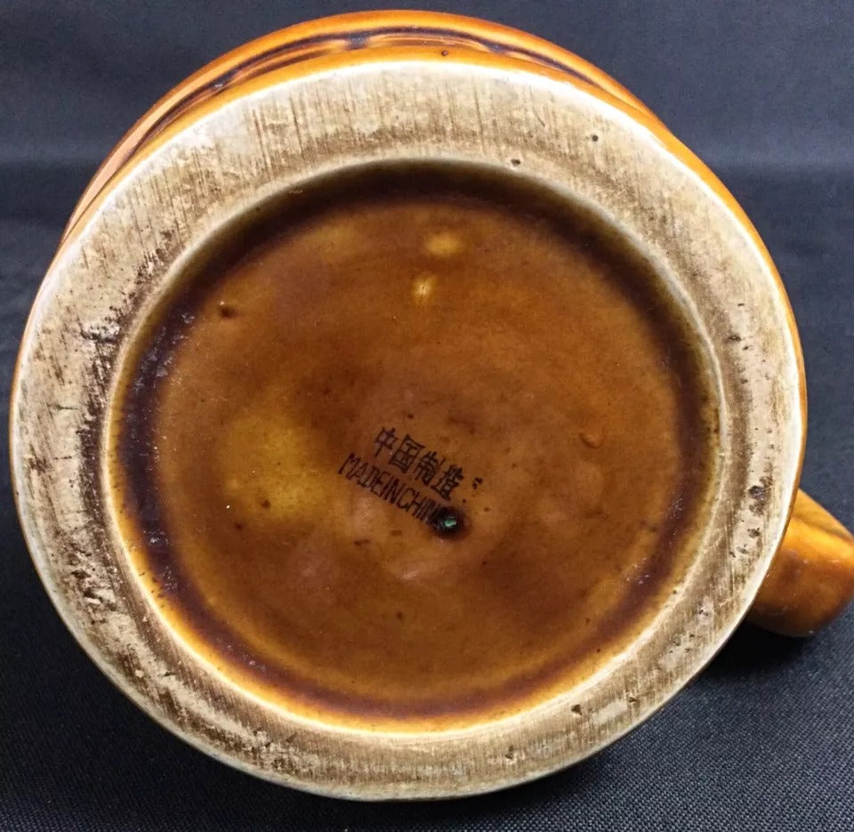 Flame pitcher texture and glazed surface detail with small chip on spout and wear on bottom

