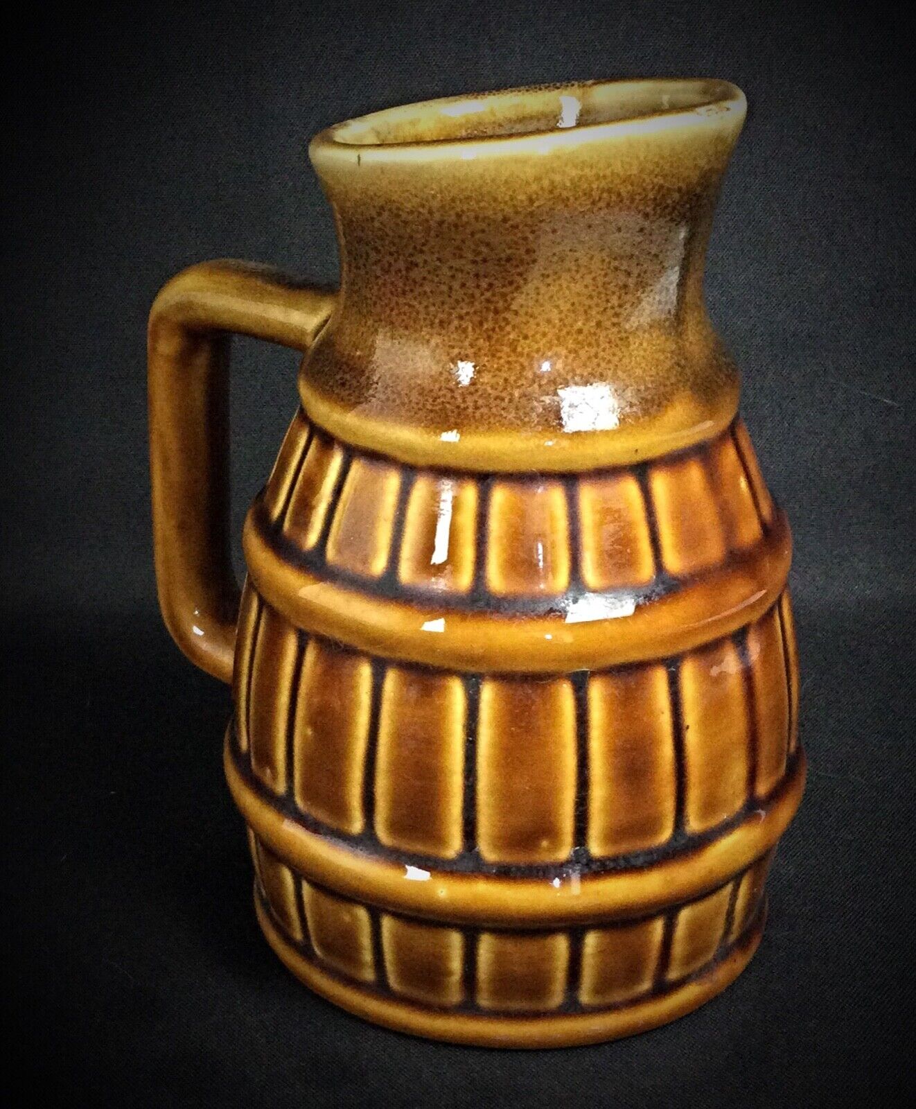 Close-up of striking flame pitcher showcasing elegant curves and unidentified maker's signature

