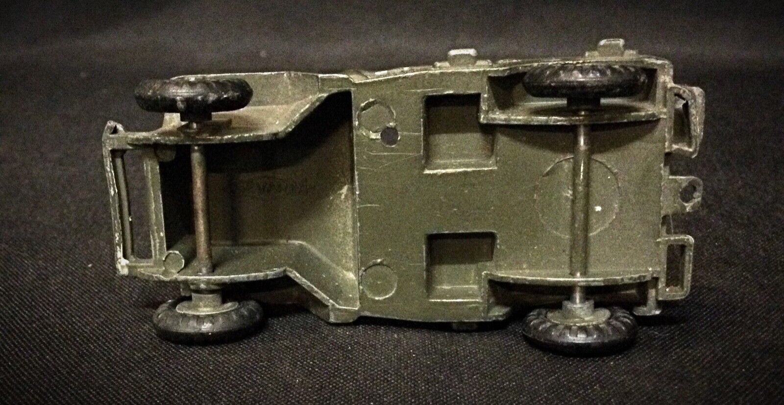 Vintage toy car placed next to a ruler for scale comparison
