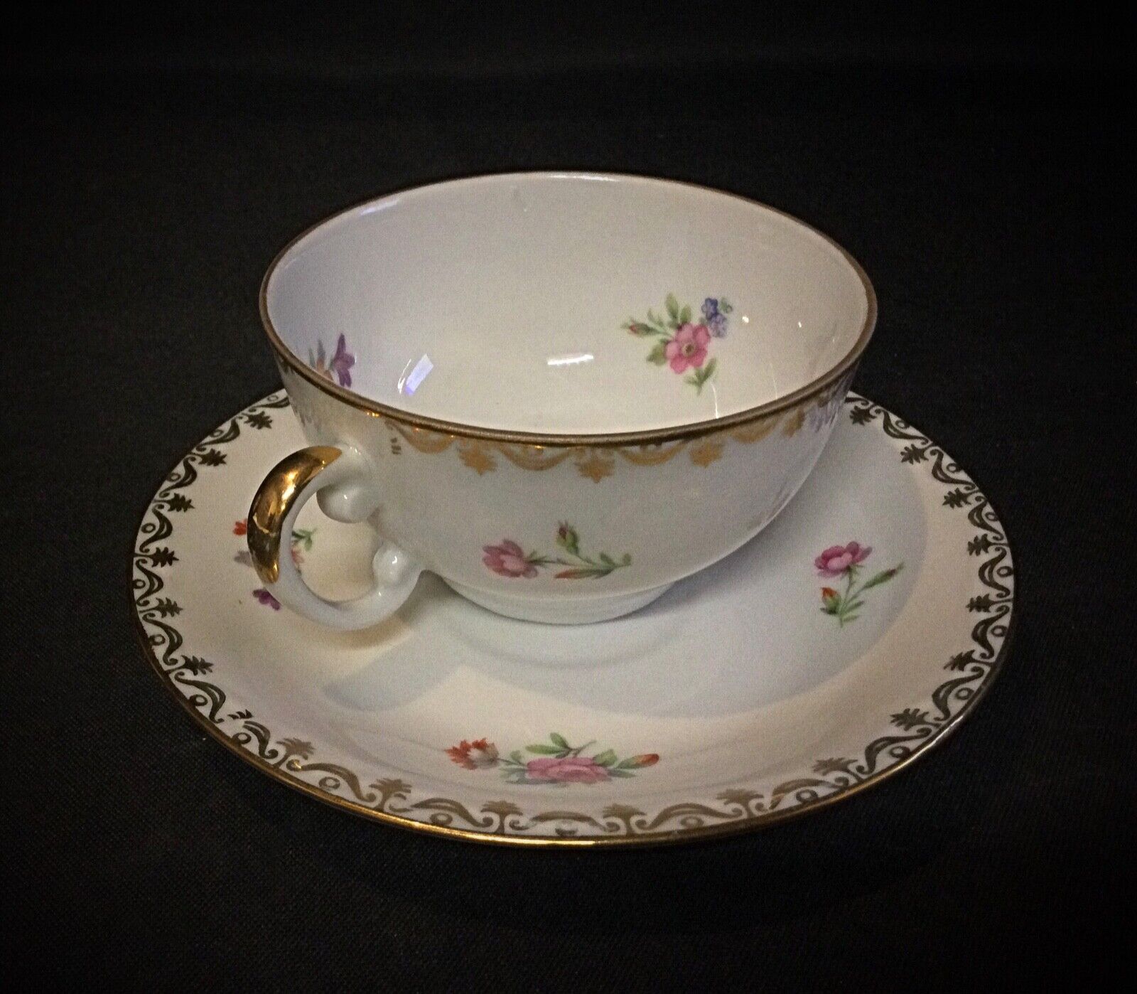 Beautiful French porcelain cup featuring delicate floral patterns and a smooth glossy finish
