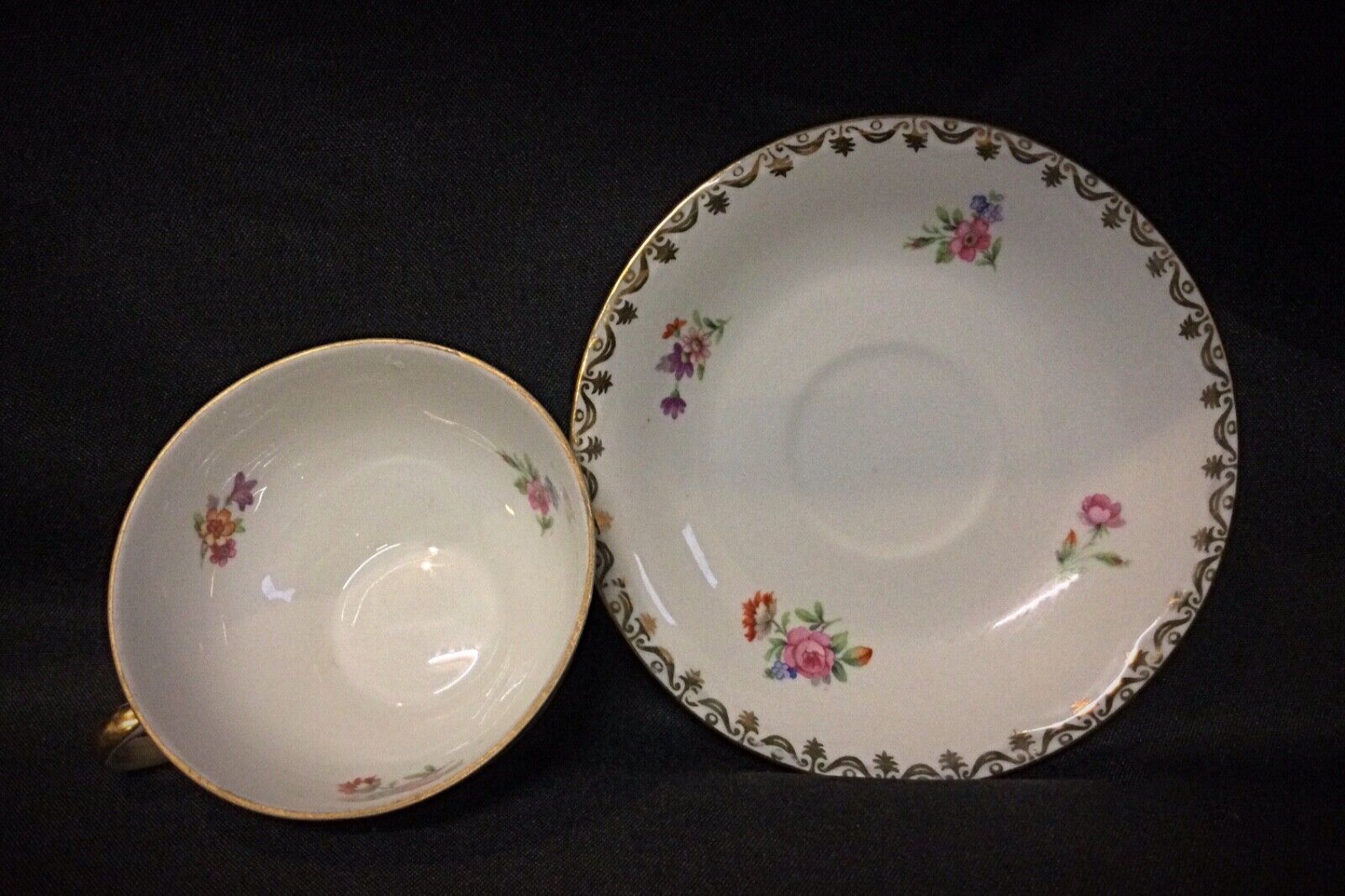 Top-down view of the vintage porcelain saucers with gold-rimmed edges
