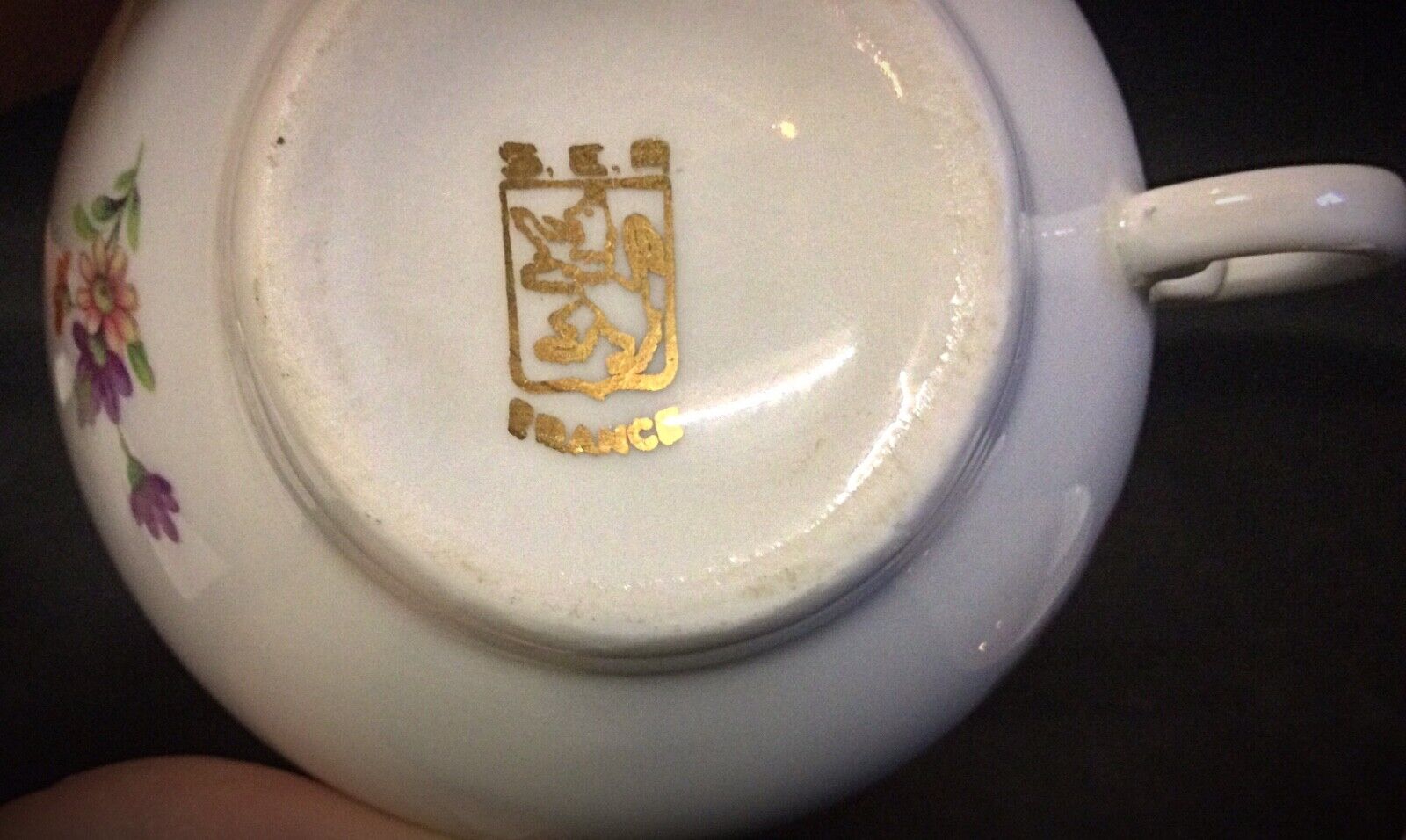Close-up of saucers with gold-trimmed edges and floral decorations
