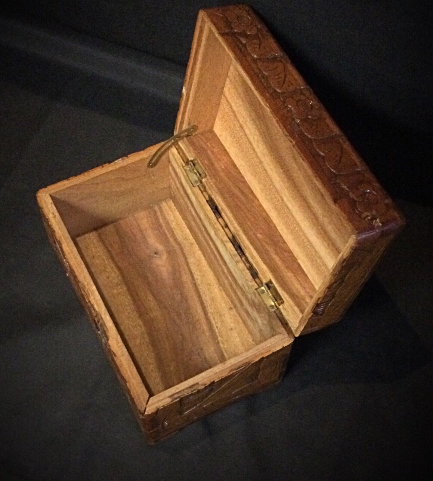 Close-up of hand-carved bas-relief design on wooden keepsake box
