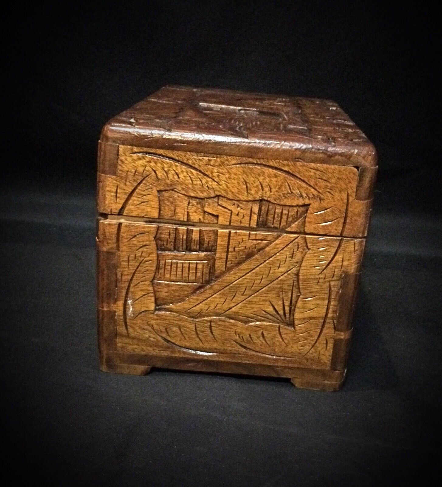 Side view of hand-crafted wooden jewelry box showing carved details
