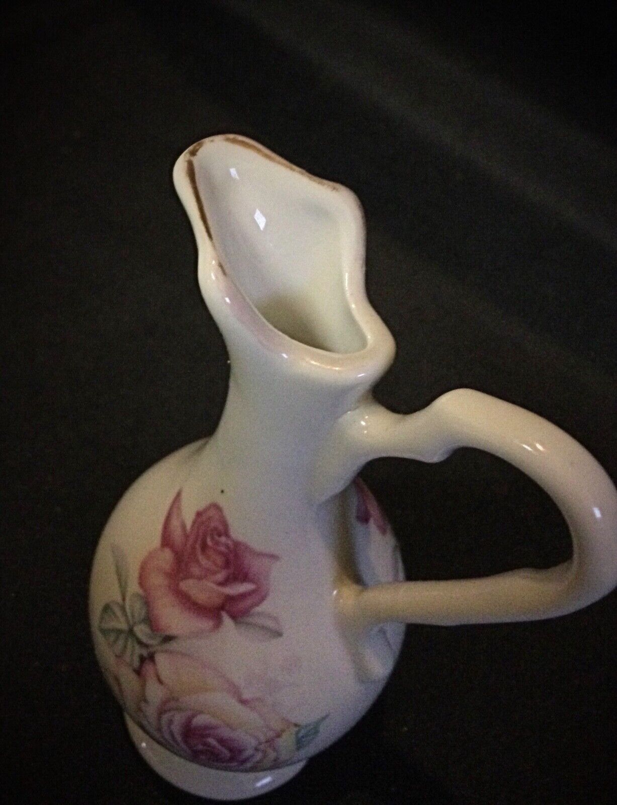 Antique collectible vase featuring an intricate floral pattern and handles
