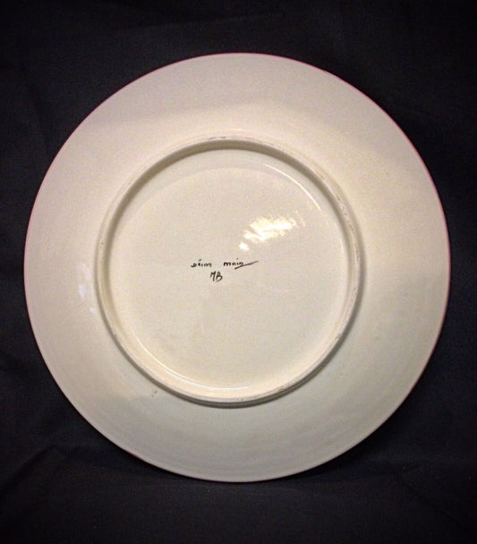 Close-up of hand-painted floral details on a vintage faience plate
