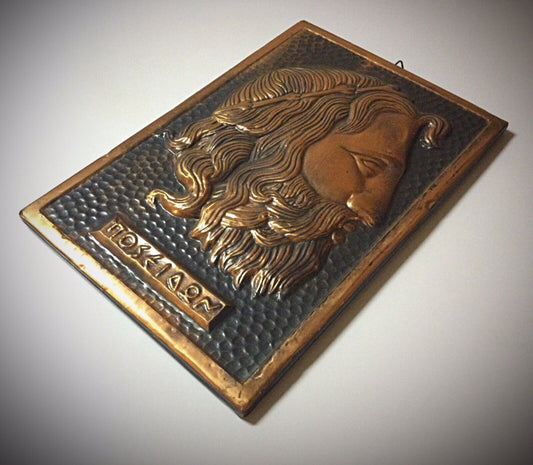 Detailed close-up of a copper relief sculpture featuring Poseidon
