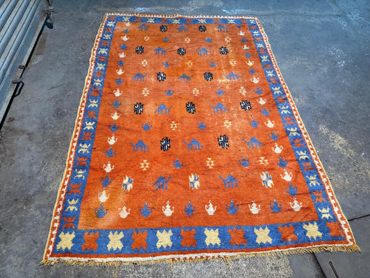 vintage Moroccan rug featuring stylized camel motifs
