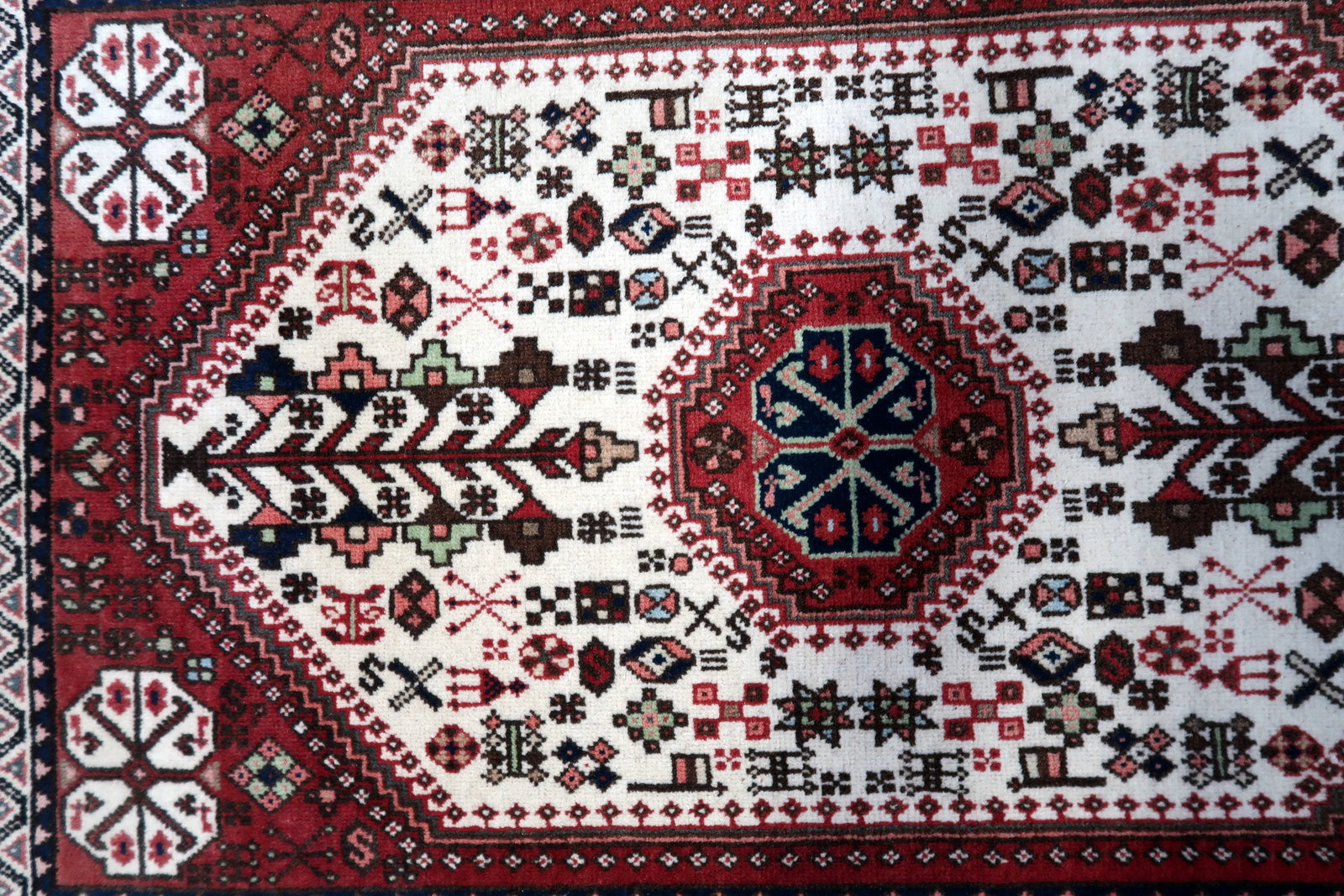 Overhead shot of the rug displaying its symmetrical patterns and faded colors
