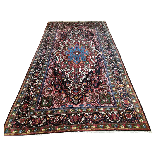 Handmade Antique Persian Bakhtiari Rug - 1920s - Vibrant colors and intricate patterns on a large antique rug.