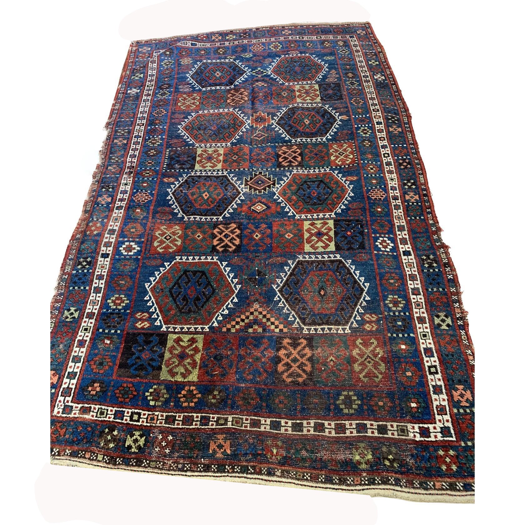 Antique Kurdish rug with deep blue field and geometric medallions

