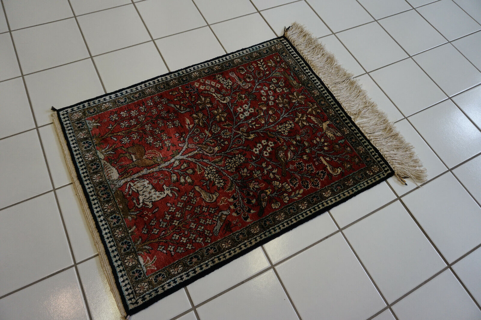 Close-up of the majestic tree motif and intricate animal motifs on the rug