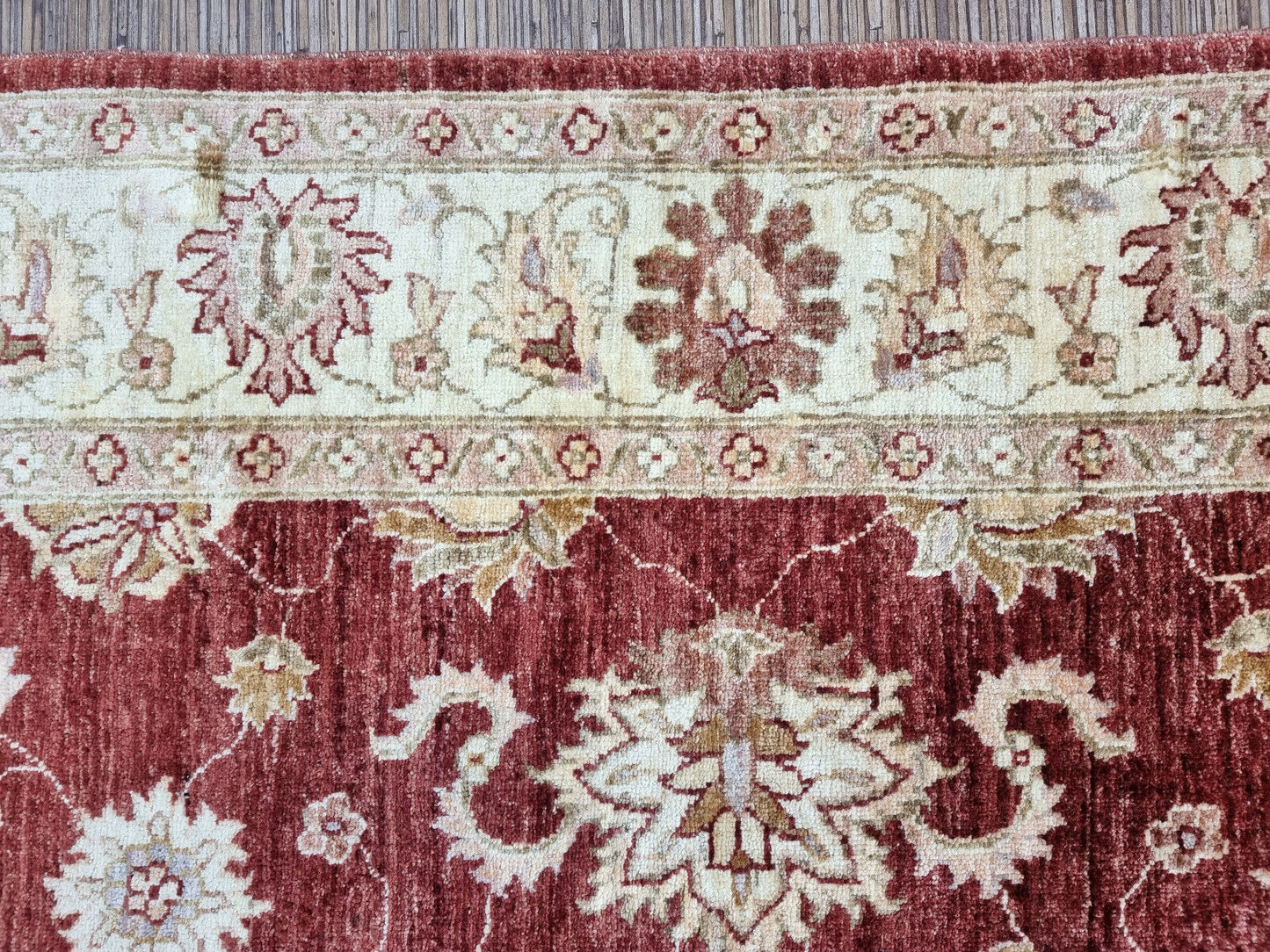Close-up of cream-colored floral motifs on Handmade Vintage Afghan Zigler Rug - Detailed view showcasing the cream-colored floral motifs woven into the rug.