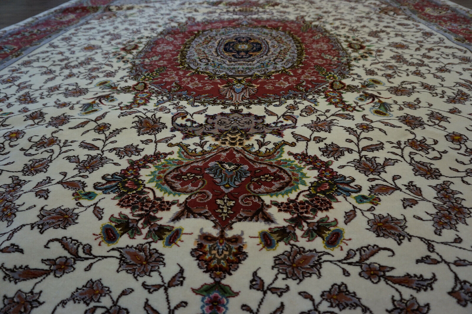 Close-up of the intricate central medallion and floral motifs on the Persian Tabriz rug