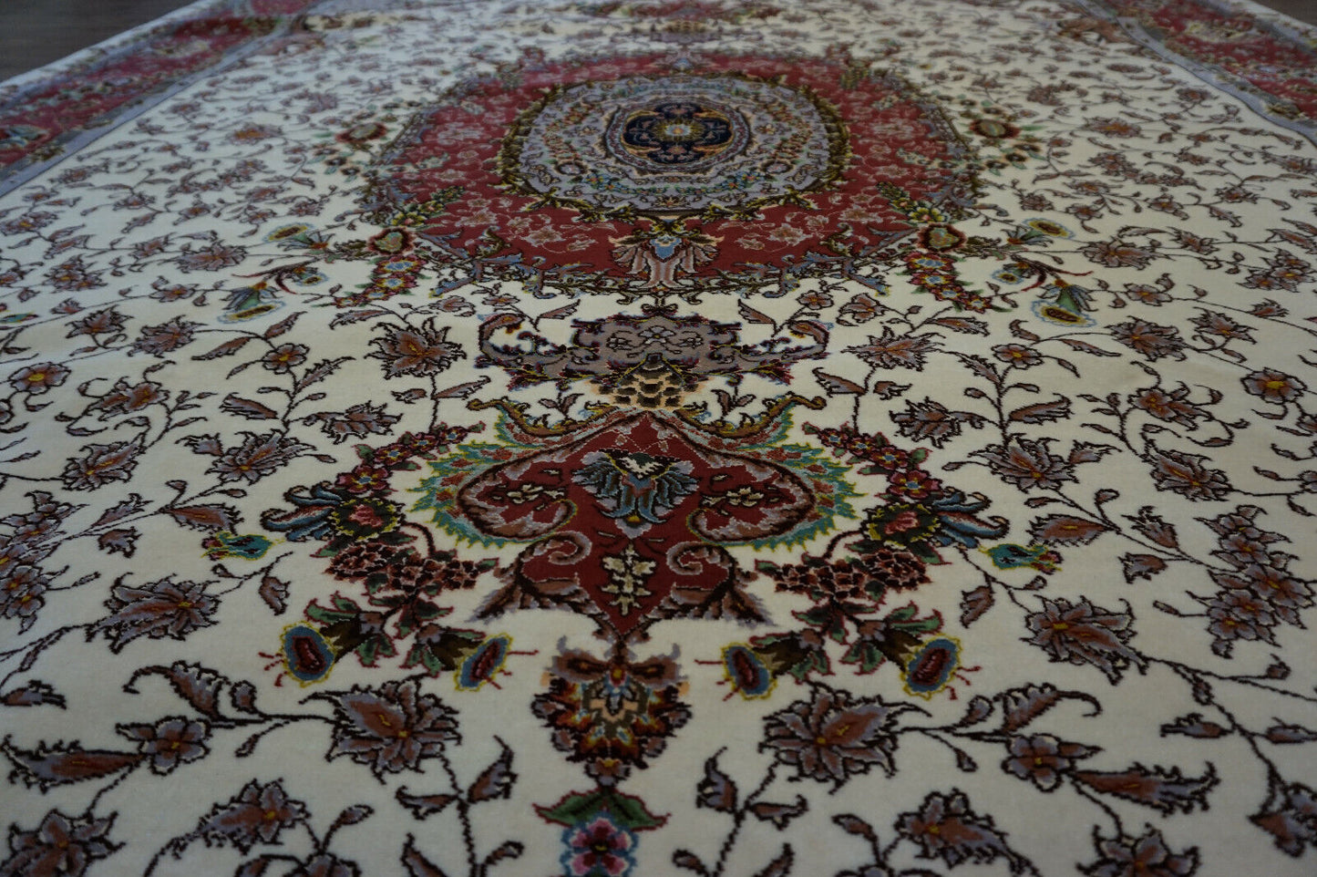 Close-up of the intricate central medallion and floral motifs on the Persian Tabriz rug