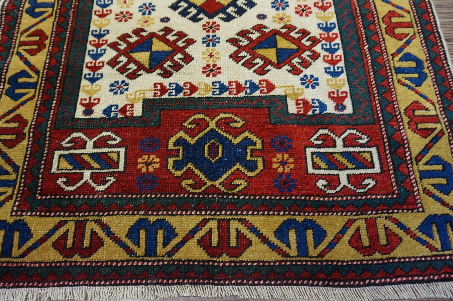 Detailed shot of the vibrant hues of red and blue on the Handmade Antique Caucasian Kazak Prayer Rug