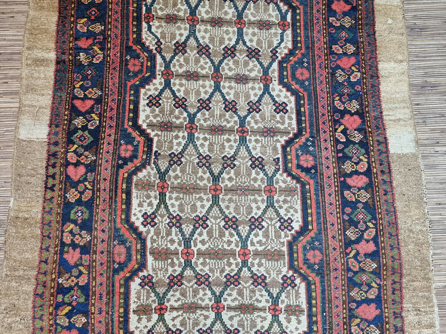 Close-up of rich navy border on Handmade Antique Persian Camel Hair Runner Rug - Detailed view showcasing the rich navy border adorned with detailed floral motifs.