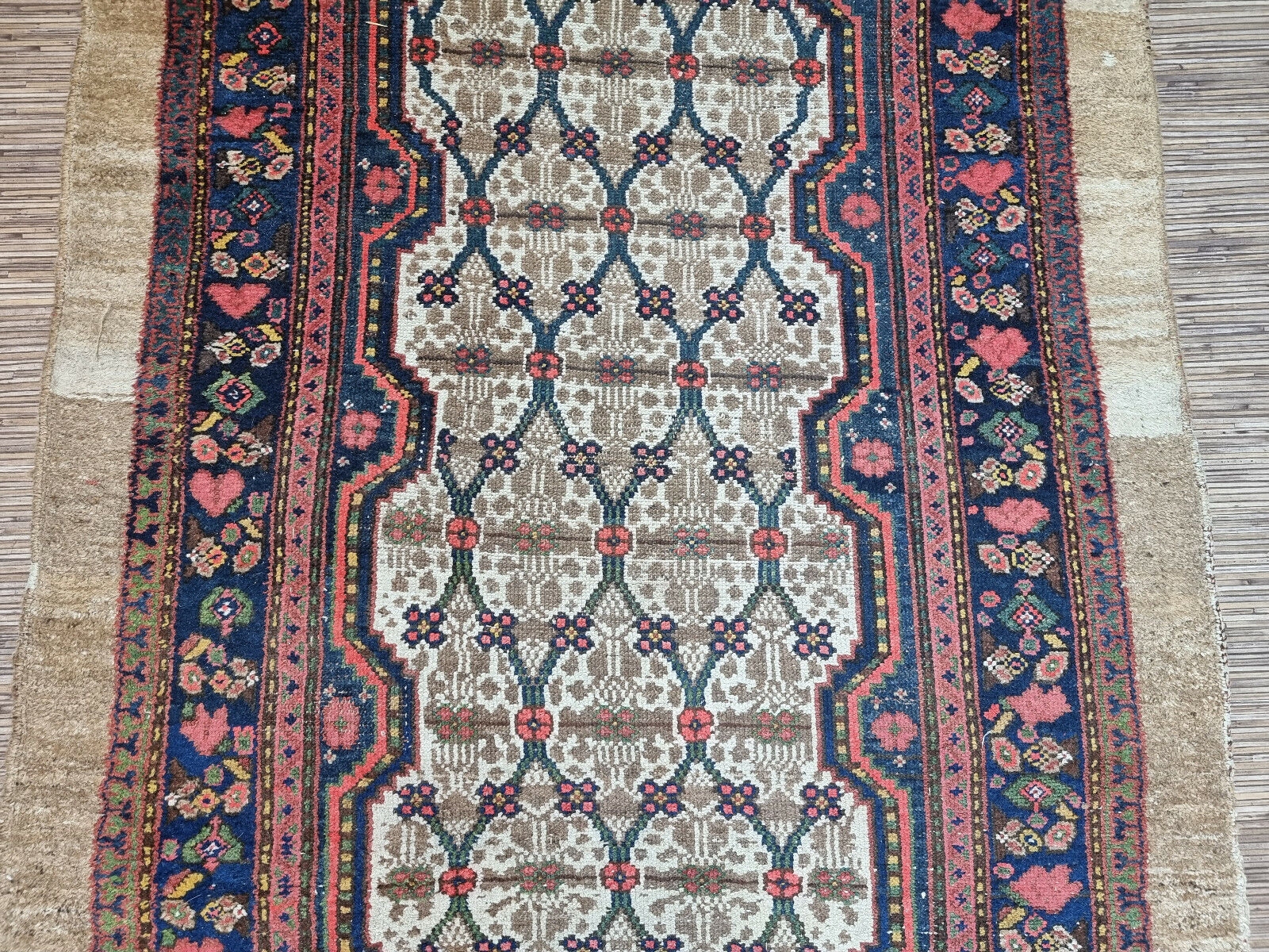 Close-up of rich navy border on Handmade Antique Persian Camel Hair Runner Rug - Detailed view showcasing the rich navy border adorned with detailed floral motifs.