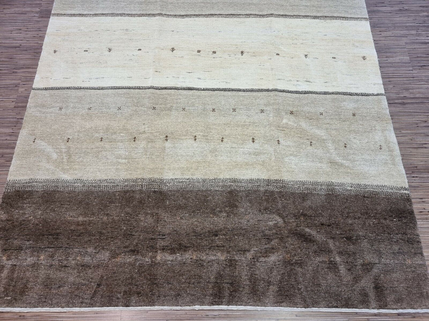 Detailed shot of the neutral tones and earthy colors on the Handmade Vintage Persian Style Gabbeh Rug