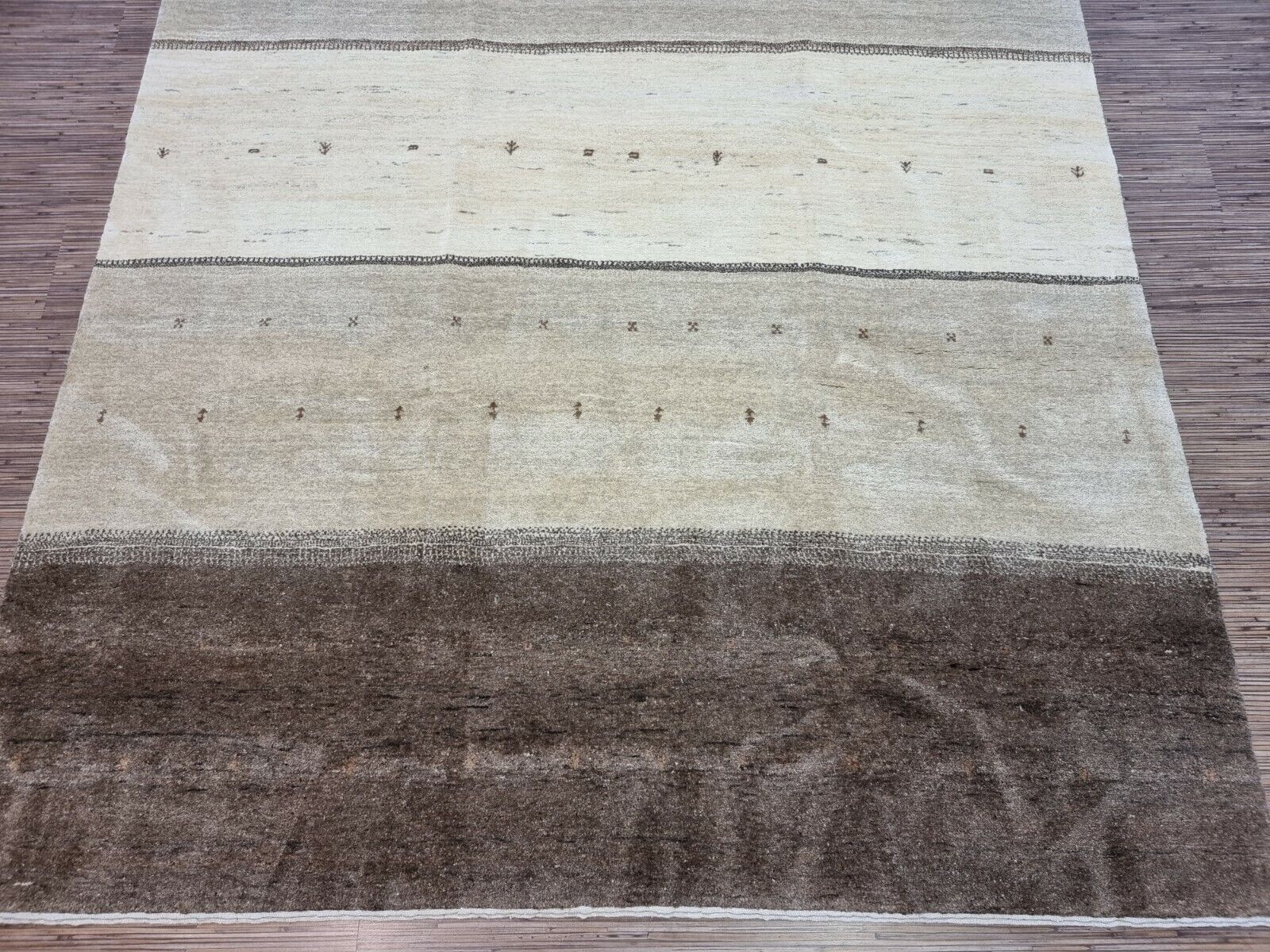 Detailed shot of the neutral tones and earthy colors on the Handmade Vintage Persian Style Gabbeh Rug