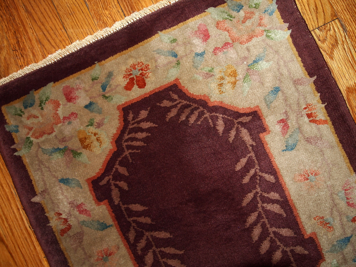 Wine burgundy Art Deco Chinese rug with beautiful light floral border. The rug is from the beginning of 20th century in original good condition.