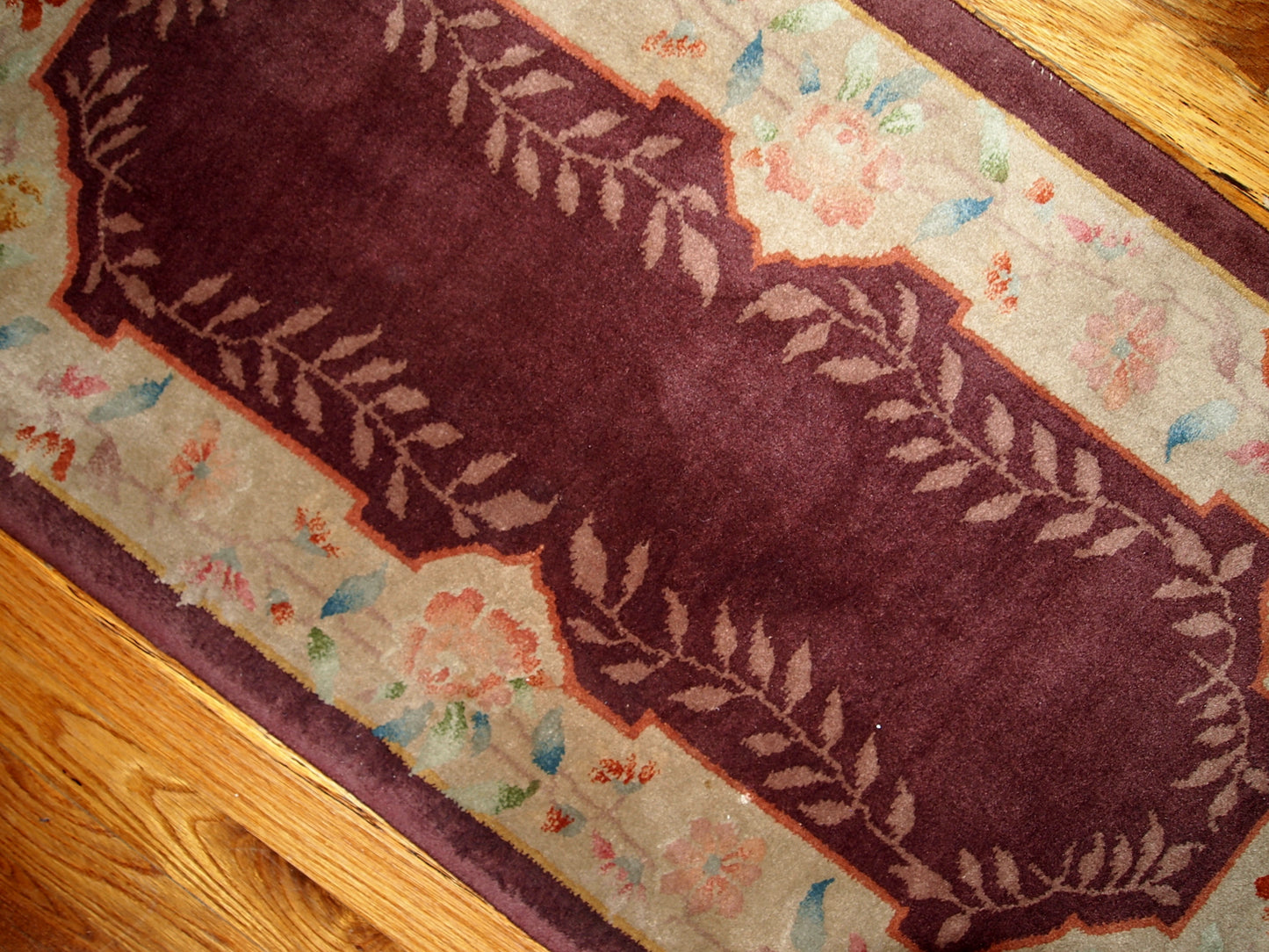 Wine burgundy Art Deco Chinese rug with beautiful light floral border. The rug is from the beginning of 20th century in original good condition.
