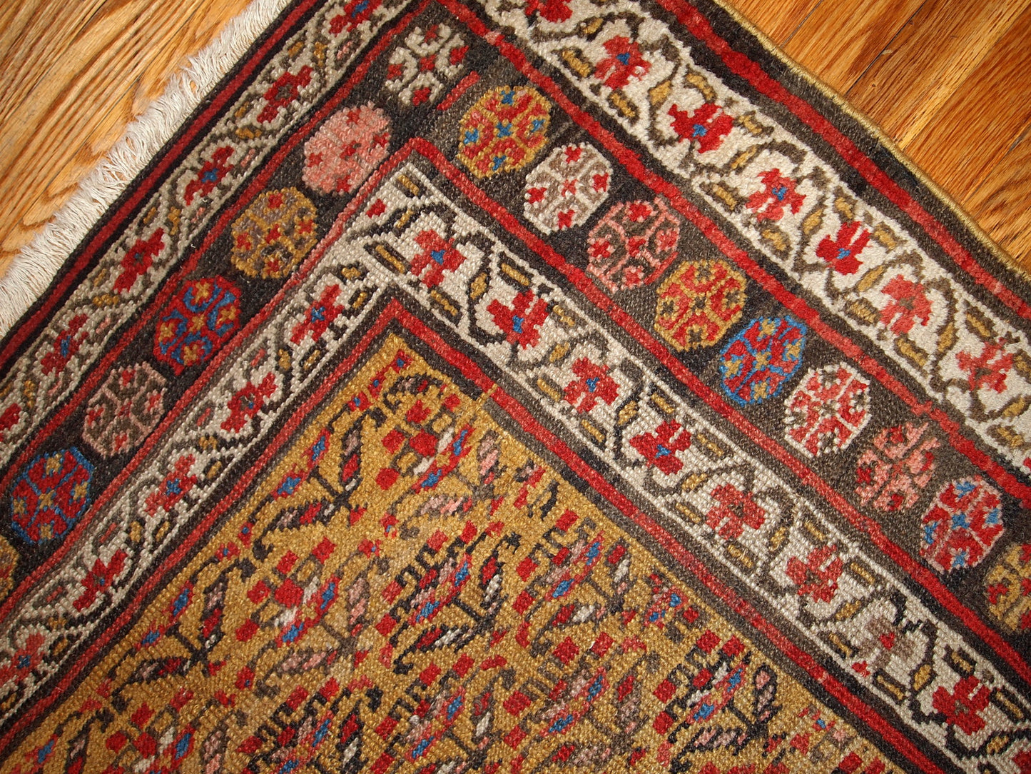 Antique Persian Kurdish rug in yellow, white and red  colors. The rug is from the end of 19th century, in good condition.