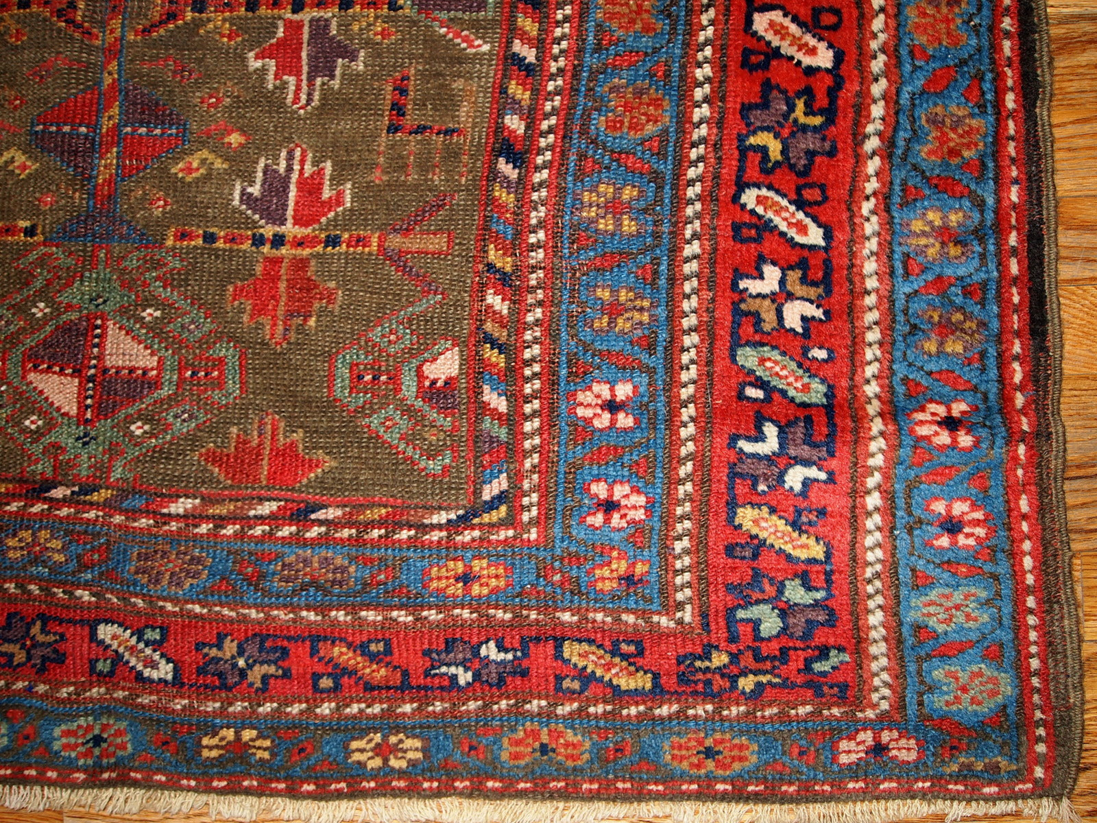 Antique Persian Kurdish rug in swampy green, red and blue colours. This rug is from the end of 19th century in good condition.