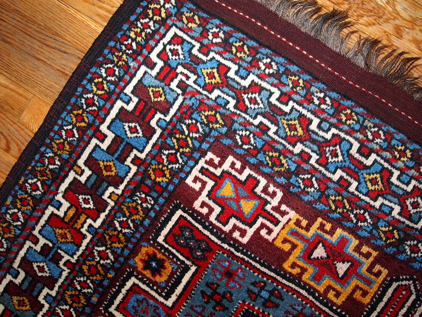 Antique Persian Kurdish rug in deep burgundy color with some golden, white and sky blue shades. This rug is in original good condition.