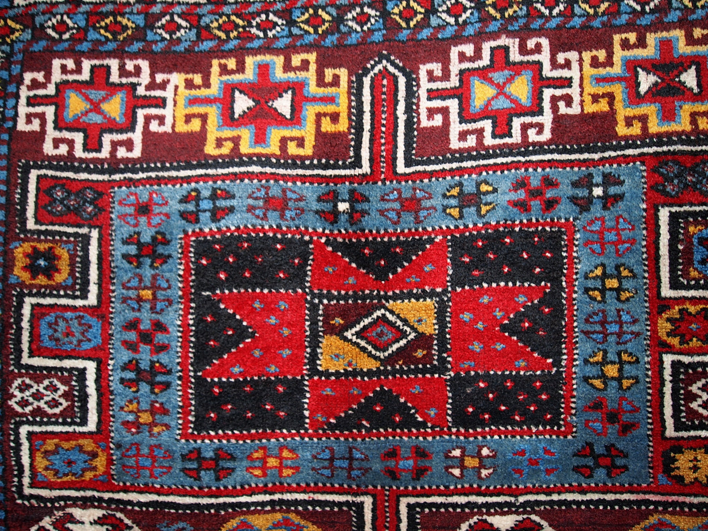 Antique Persian Kurdish rug in deep burgundy color with some golden, white and sky blue shades. This rug is in original good condition.