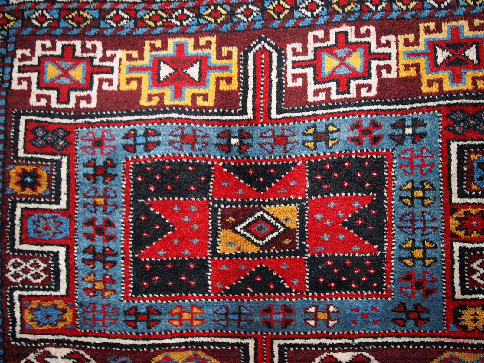 Antique Persian Kurdish rug in deep burgundy color with some golden, white and sky blue shades. This rug is in original good condition.