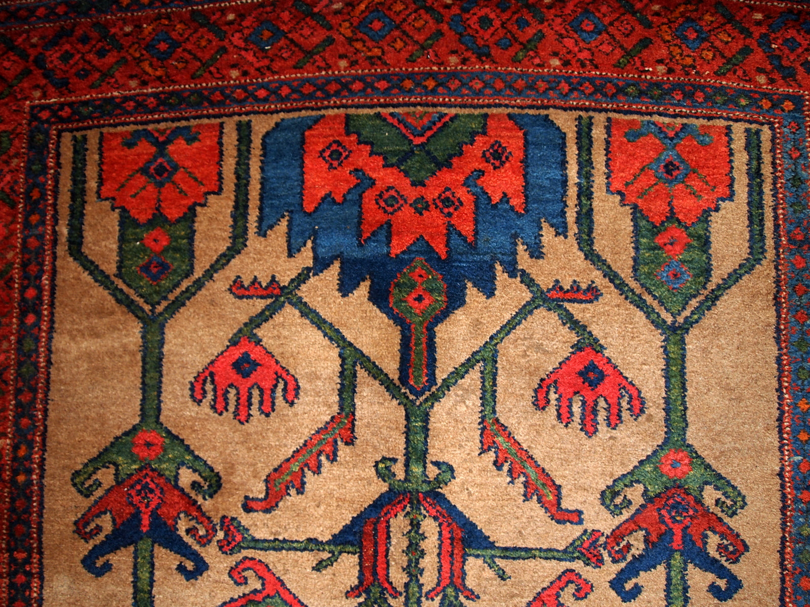 Antique Persian Kurdish rug in light brown background color. Very primitive tribal design with large ornaments. The rug is in original good condition.