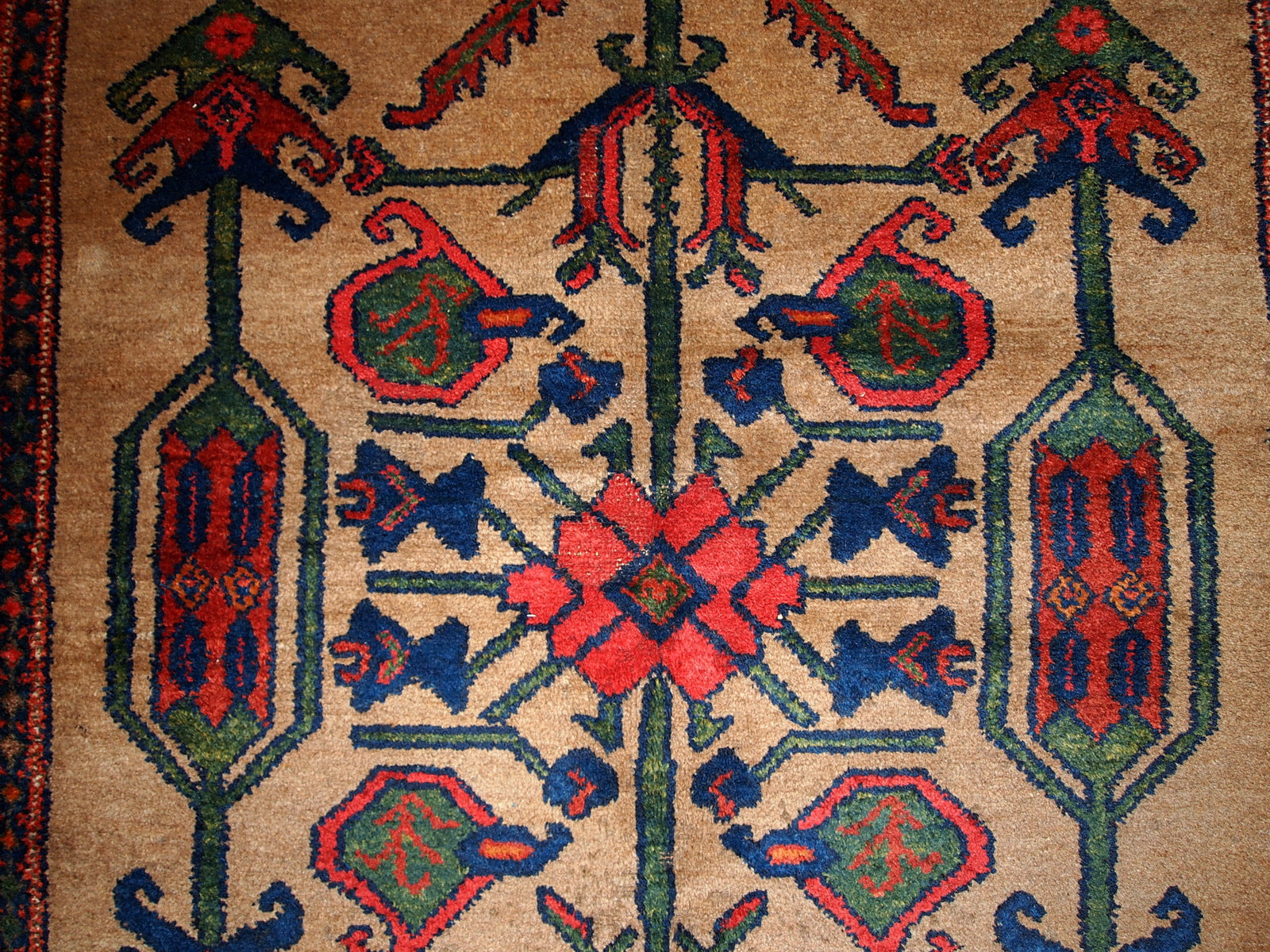 Antique Persian Kurdish rug in light brown background color. Very primitive tribal design with large ornaments. The rug is in original good condition.
