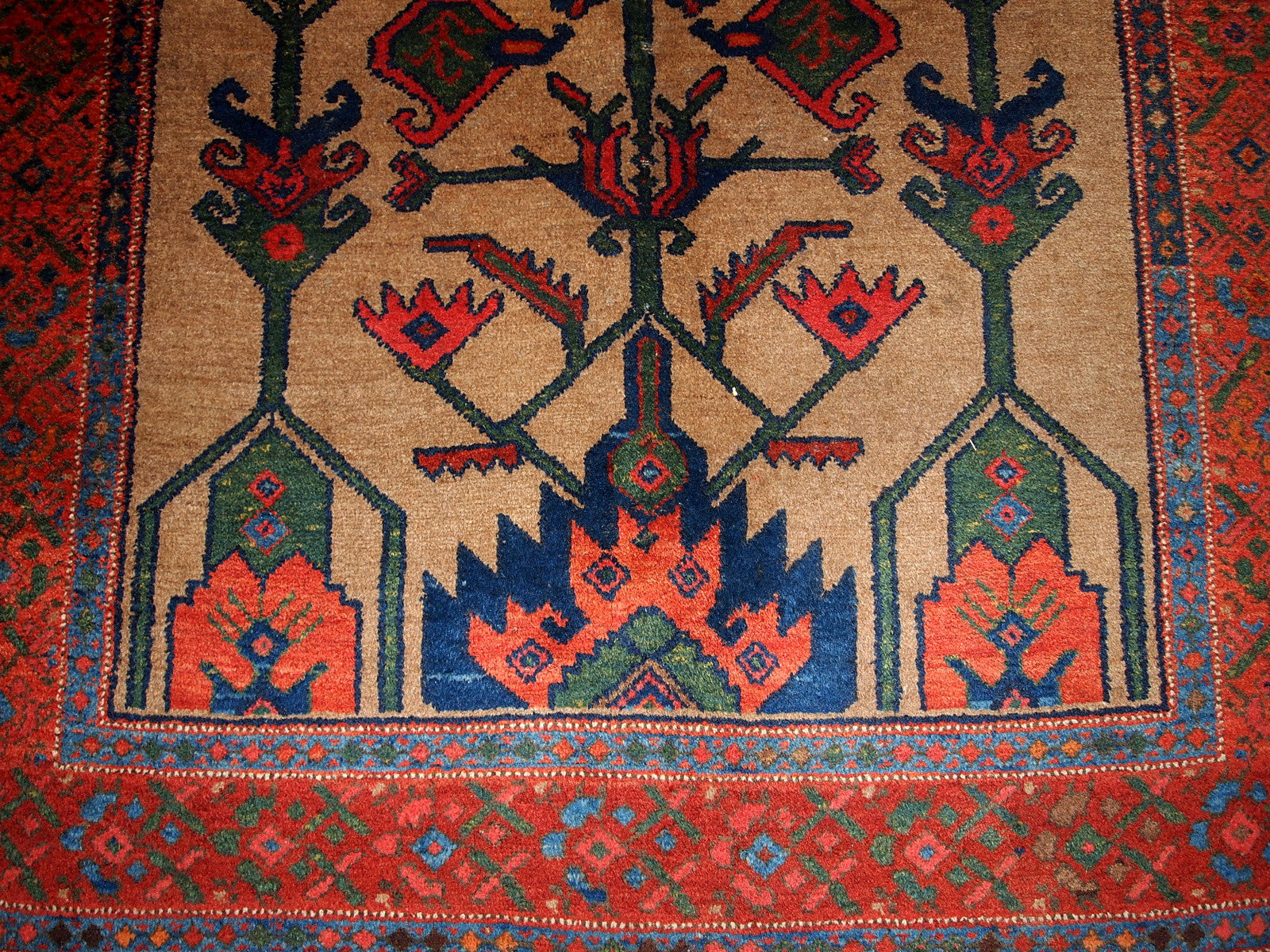 Antique Persian Kurdish rug in light brown background color. Very primitive tribal design with large ornaments. The rug is in original good condition.