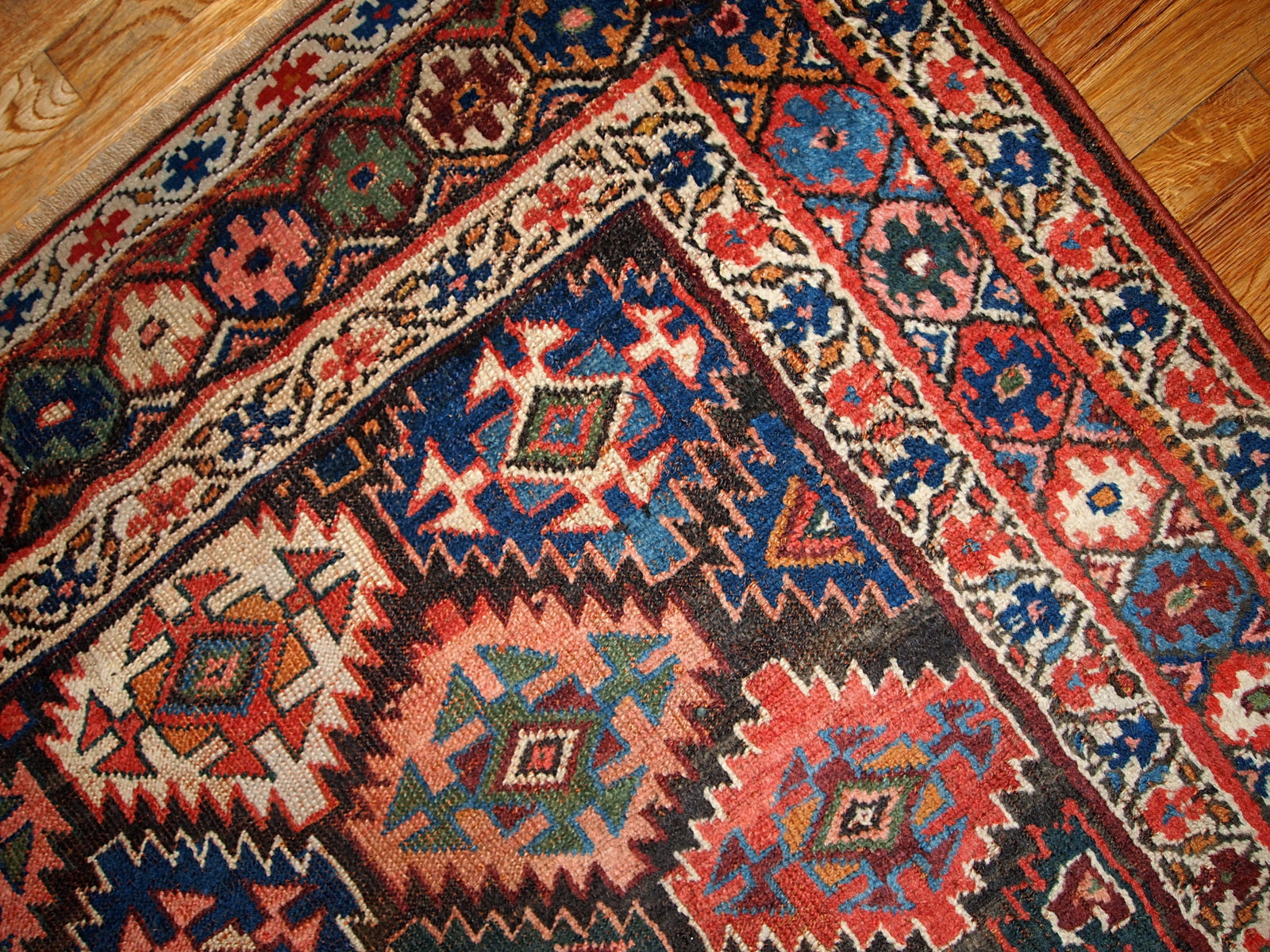 Antique Persian Kurdish rug in chocolate brown background color and repeating pattern. This rug has Jaff Kurdish design. It is in original good condition.