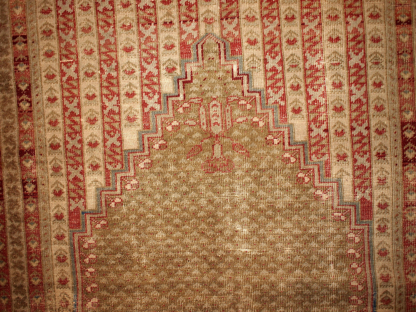 Antique collectible prayer Turkish Ghurdes rug in distressed condition. The rug is in olive green color and lots of narrow borders in burgundy, red and beige shades. 