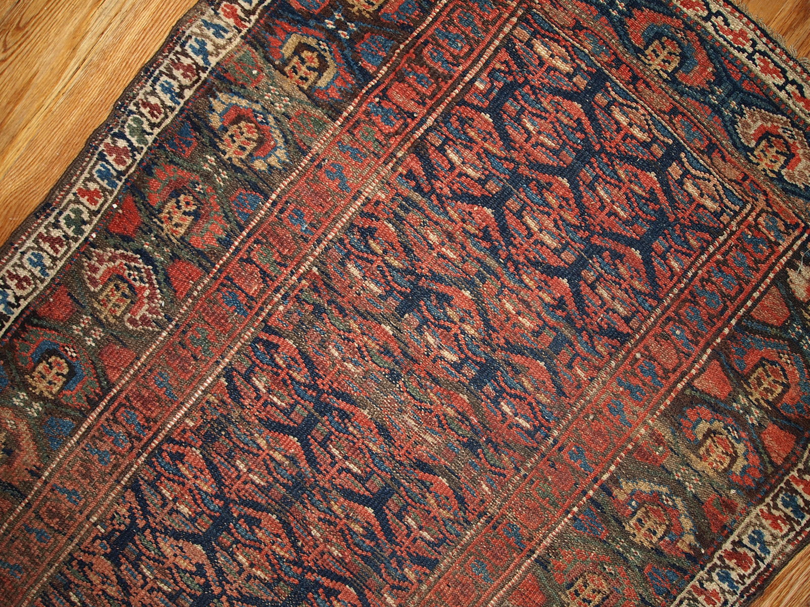 Antique hand made Persian Kurdish runner in navy blue and red shades. The rug is from the beginning of 20th century in original good condition.
