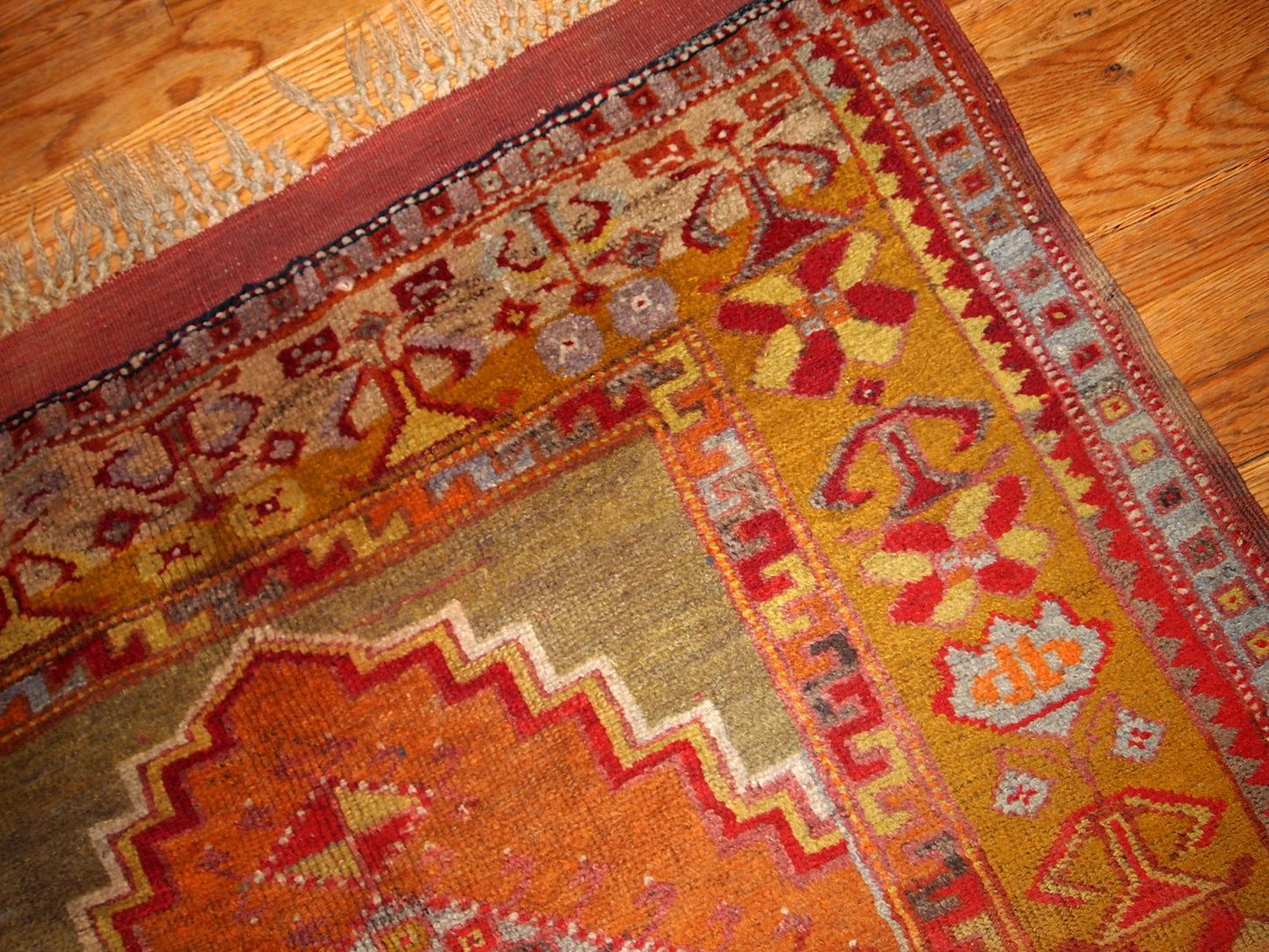Antique Turkish Anatolian rug in soft tones of green, orange, red and brown.  The rug is from the beginning of 20th century and in original good condition.