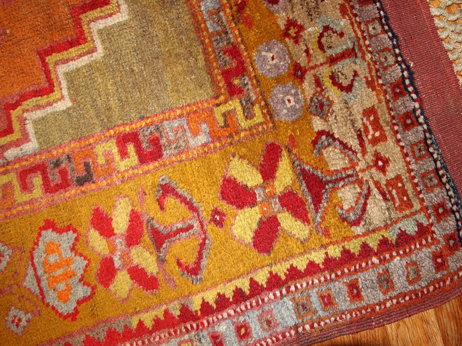 Antique Turkish Anatolian rug in soft tones of green, orange, red and brown.  The rug is from the beginning of 20th century and in original good condition.