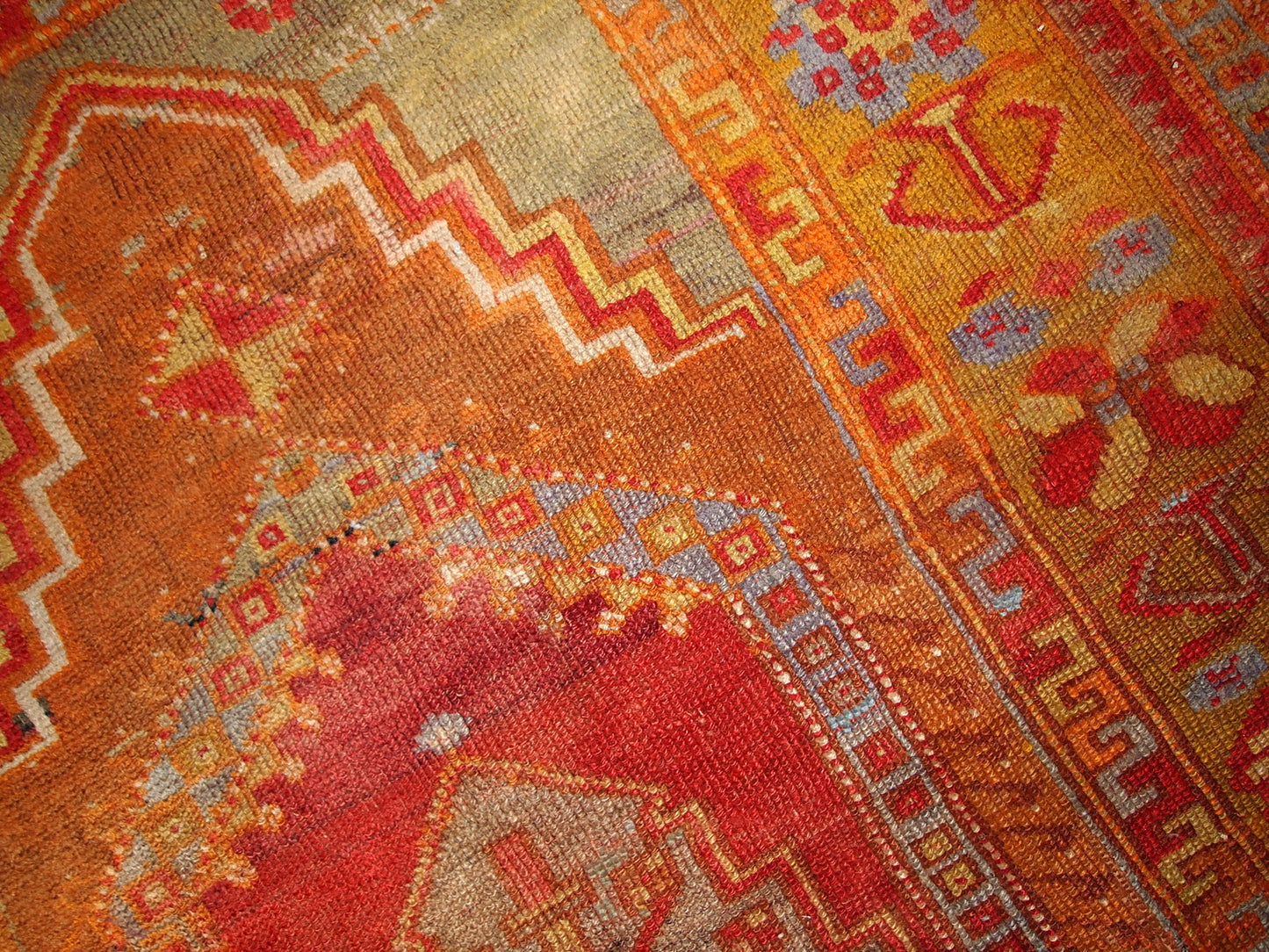 Antique Turkish Anatolian rug in soft tones of green, orange, red and brown.  The rug is from the beginning of 20th century and in original good condition.