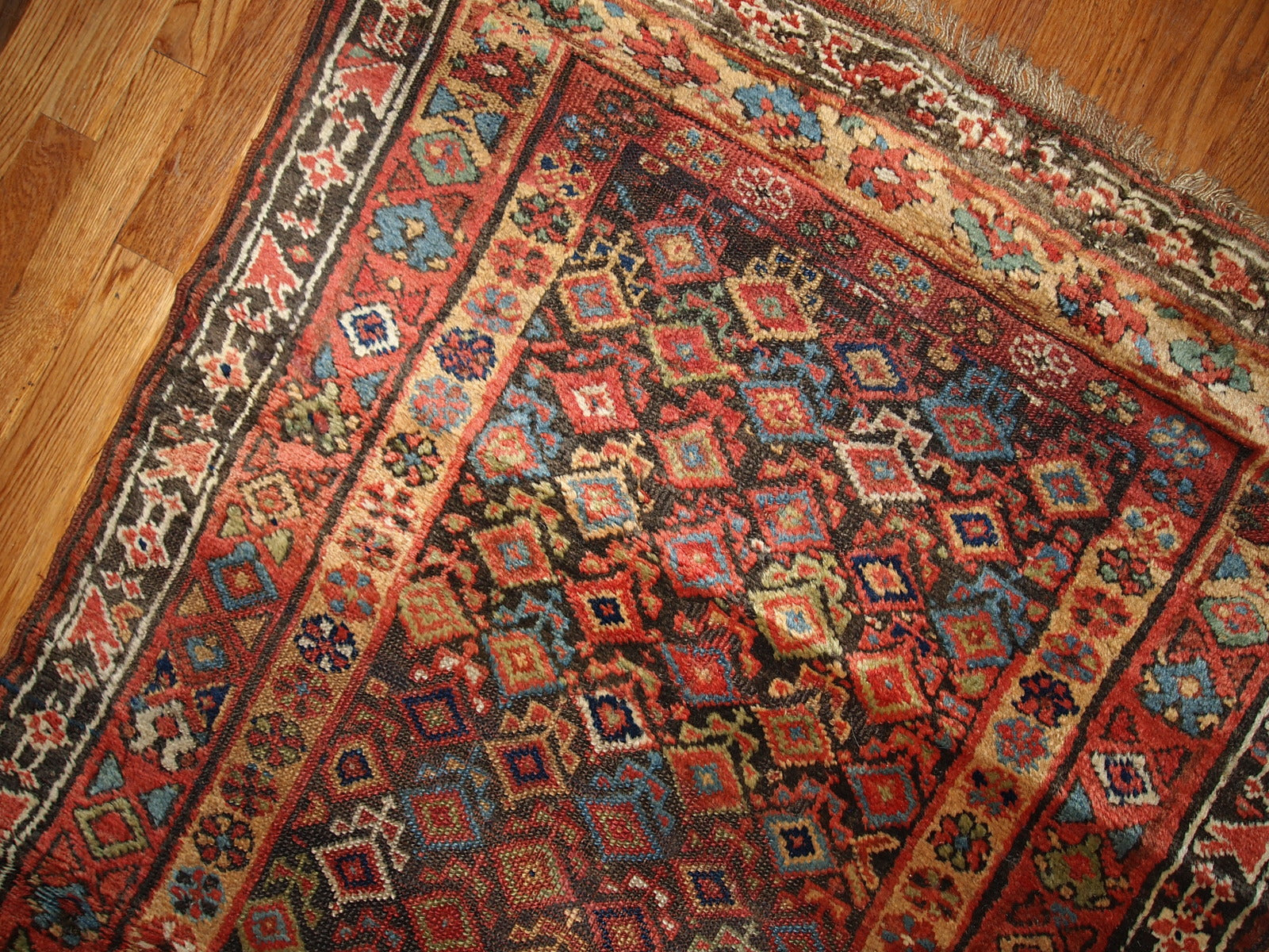 Antique hand made Kurdish runner in traditional Persian geometric design all over the chocolate brown field. The rug is from the end of 19th century in original good condition.