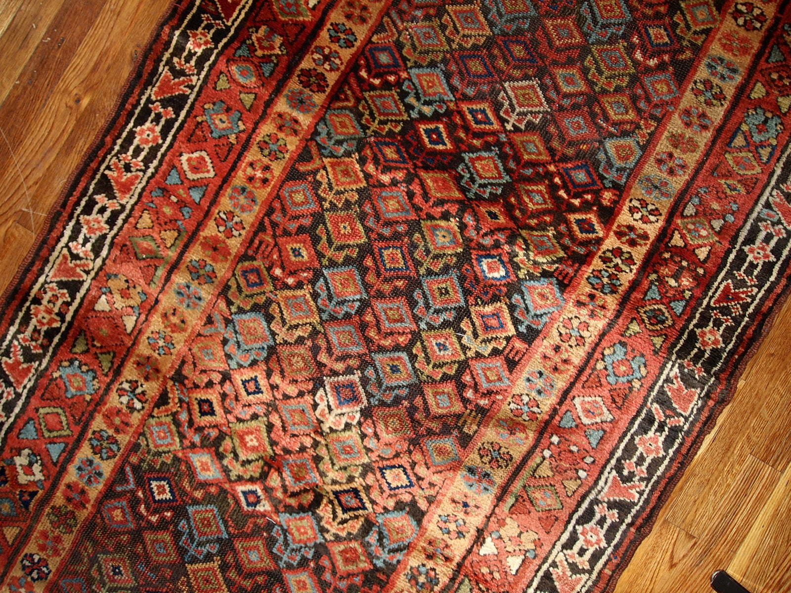 Antique hand made Kurdish runner in traditional Persian geometric design all over the chocolate brown field. The rug is from the end of 19th century in original good condition.