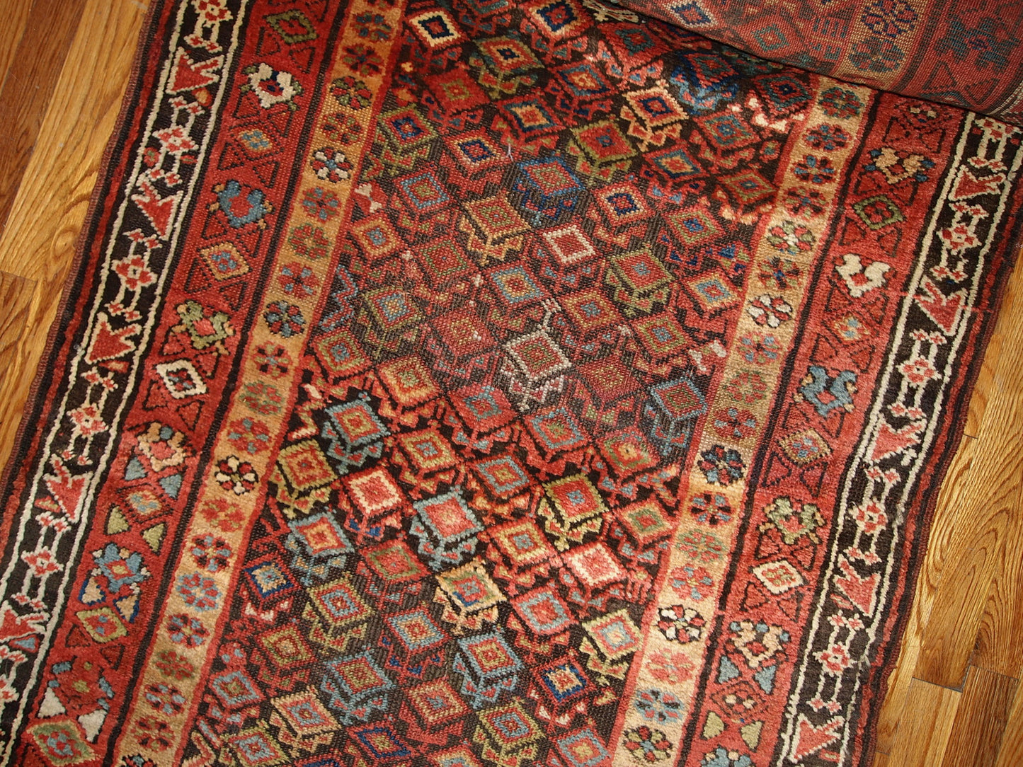 Antique hand made Kurdish runner in traditional Persian geometric design all over the chocolate brown field. The rug is from the end of 19th century in original good condition.