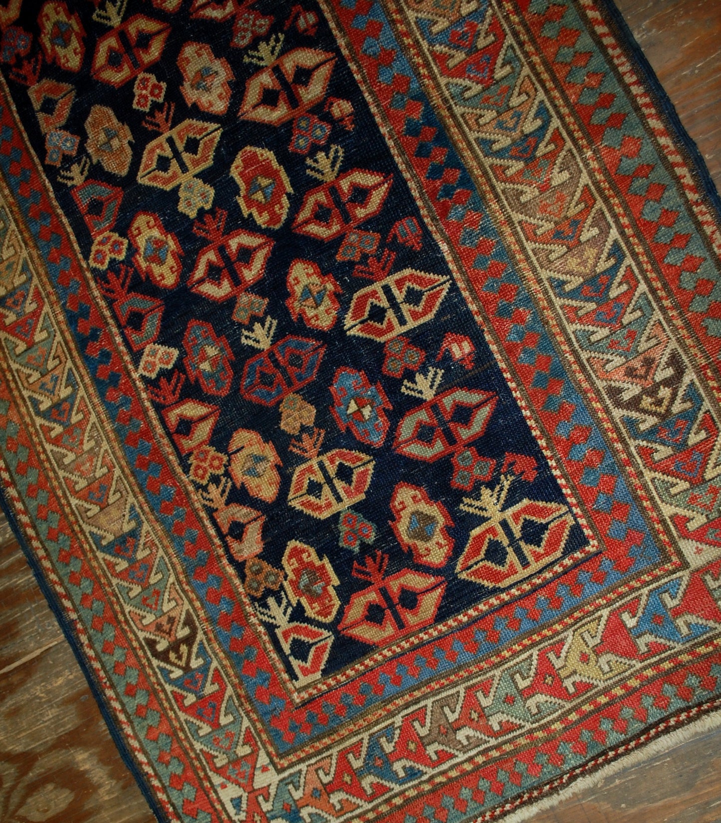 Antique handmade Caucasian Gendje rug in good condition. The rug has dark blue field covered in tribal figures, made in the end of 19th century.