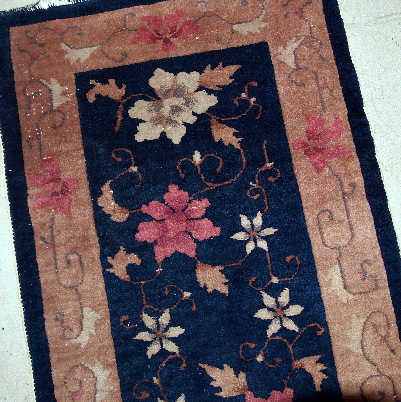 Art Deco Chinese rug in original good condition. The rug is in navy blue shade with peach border. 