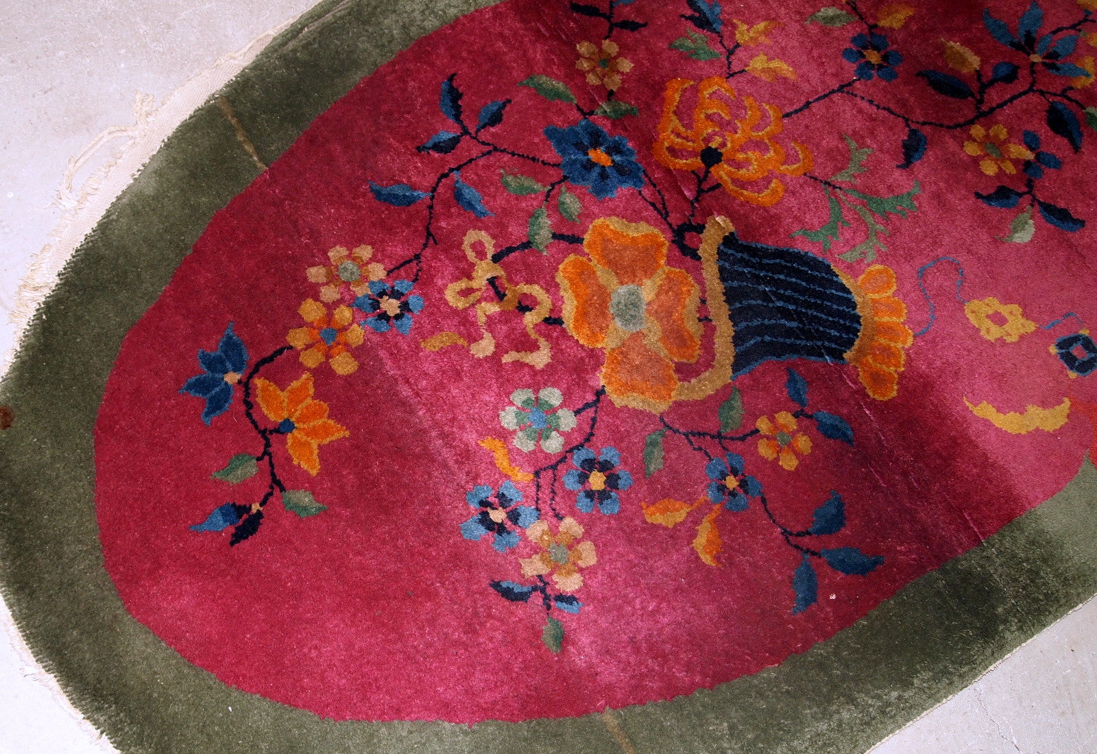 Handmade antique oval decorative rug from China in original good condition. The rug is in fuchsia and green shades.