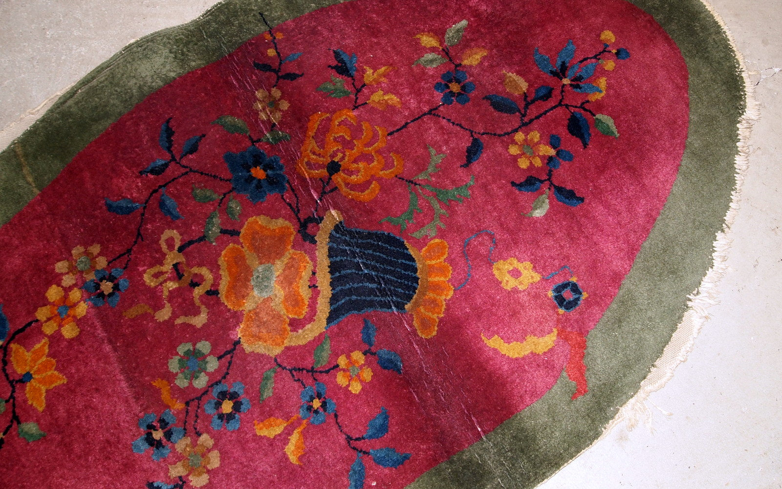 Handmade antique oval decorative rug from China in original good condition. The rug is in fuchsia and green shades.