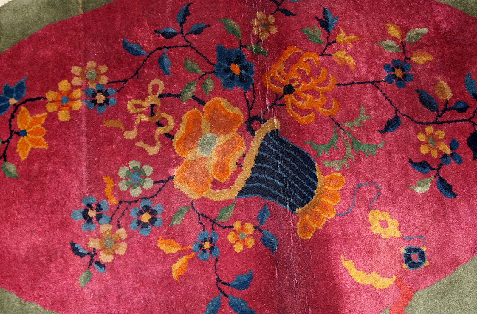 Handmade antique oval decorative rug from China in original good condition. The rug is in fuchsia and green shades.