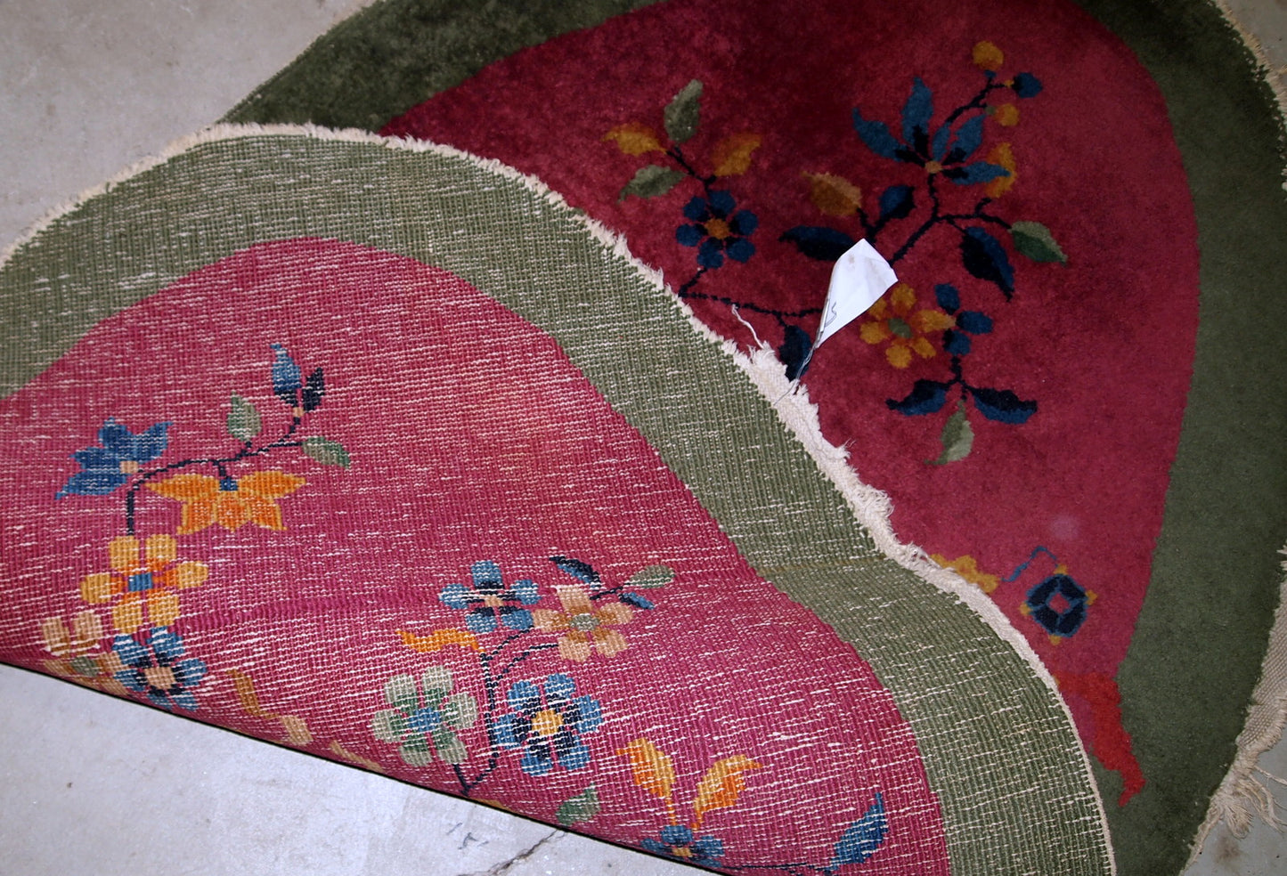 Handmade antique oval decorative rug from China in original good condition. The rug is in fuchsia and green shades.