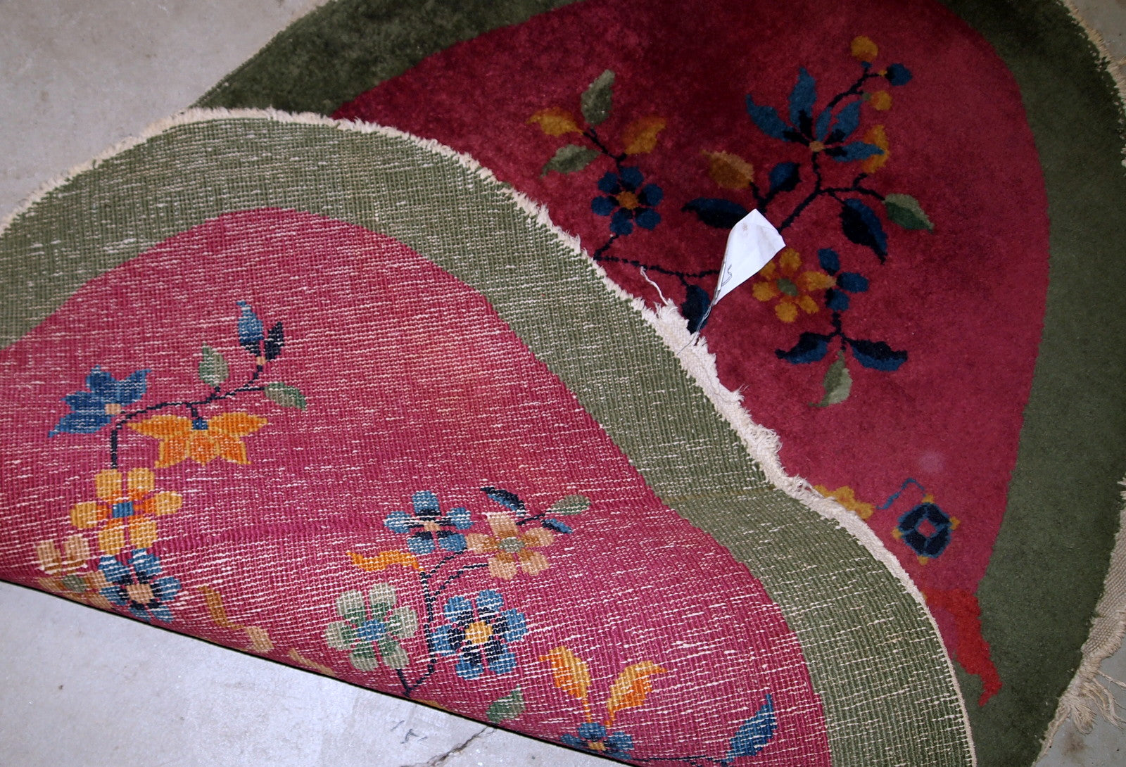 Handmade antique oval decorative rug from China in original good condition. The rug is in fuchsia and green shades.
